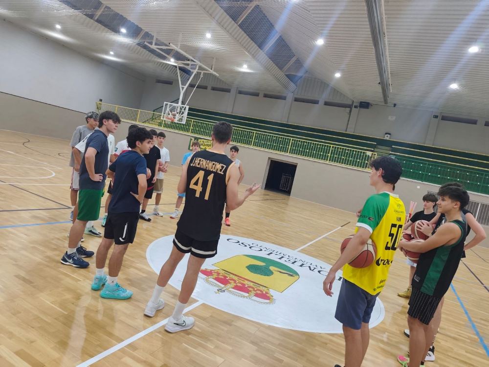 Jugadores del U19 del Val Brokers CB Tomelloso reunidos en el círculo central del pabellón San José en el primer entrenamiento de la pretemporada
