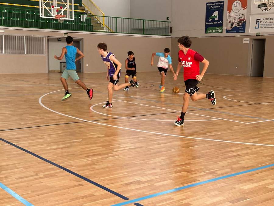 Participantes del Campus de Pretemporada del CB Tomelloso corriendo en el pabellón San José
